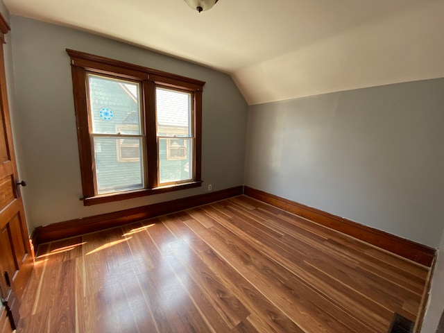 bonus room with wood-type flooring and vaulted ceiling