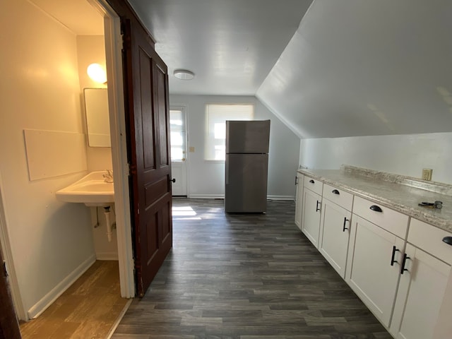 interior space featuring dark hardwood / wood-style floors, sink, and vaulted ceiling