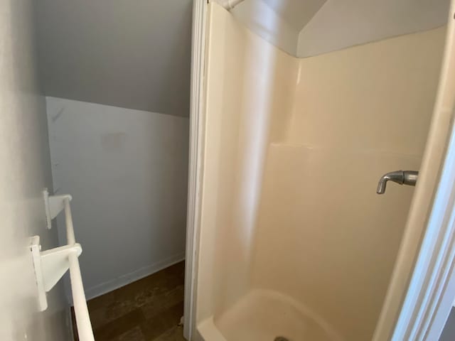 bathroom with hardwood / wood-style floors, a shower, and lofted ceiling