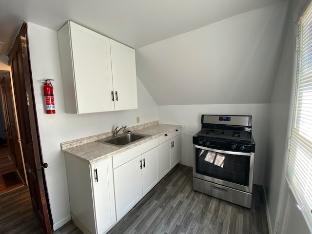 kitchen with dark wood-type flooring, sink, white cabinetry, lofted ceiling, and stainless steel range with gas stovetop