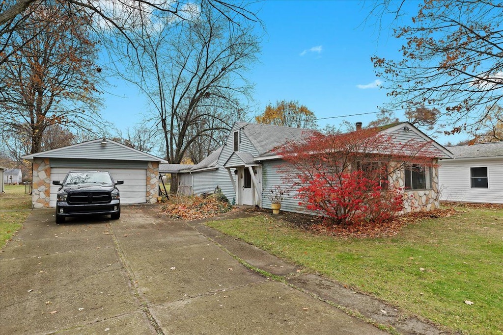 view of front facade with a garage, an outdoor structure, and a front yard