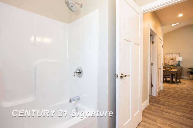 bathroom featuring wood-type flooring and vaulted ceiling