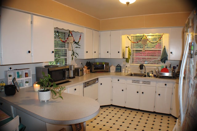5831 Stadium Dr, Kalamazoo, MI 49009 - kitchen with stainless steel microwave, a sink, white cabinetry, and a peninsula