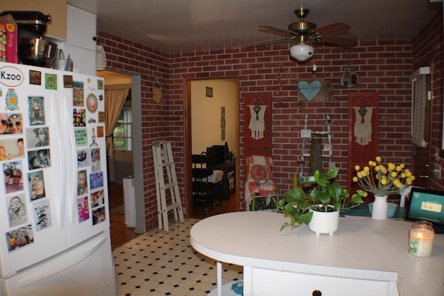 5831 Stadium Dr, Kalamazoo, MI 49009 - kitchen featuring ceiling fan, white fridge with ice dispenser, and brick wall