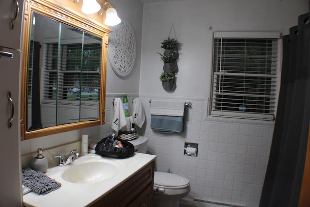 5831 Stadium Dr, Kalamazoo, MI 49009 - bathroom with tile walls, a wainscoted wall, vanity, and toilet