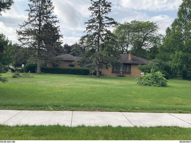 5831 Stadium Dr, Kalamazoo, MI 49009 - view of front of house featuring a chimney, a front yard, and brick siding