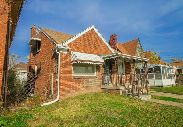 4224 W Davison, Detroit, MI 48238 - view of front facade featuring a chimney, brick siding, a sunroom, and a shingled roof