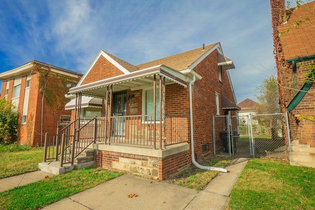 4224 W Davison, Detroit, MI 48238 - view of front of home with a porch, a gate, brick siding, roof with shingles, and a front lawn