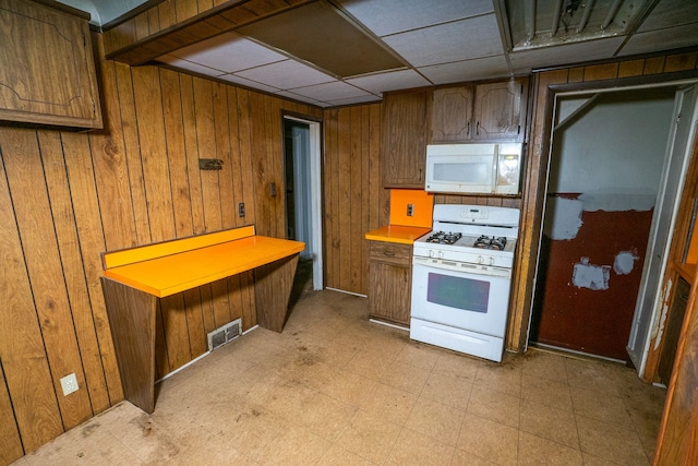 kitchen with white appliances and wood walls