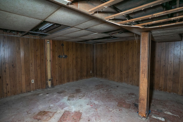 basement featuring wooden walls