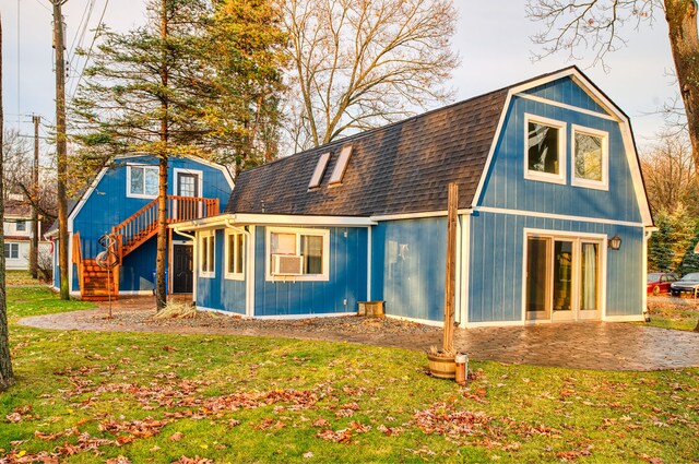 rear view of property with cooling unit, a patio area, and a lawn