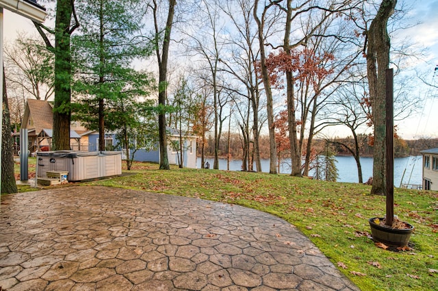 view of patio featuring a water view and a hot tub