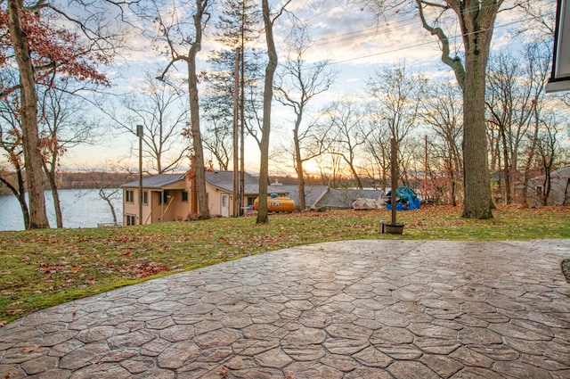 patio terrace at dusk featuring a water view