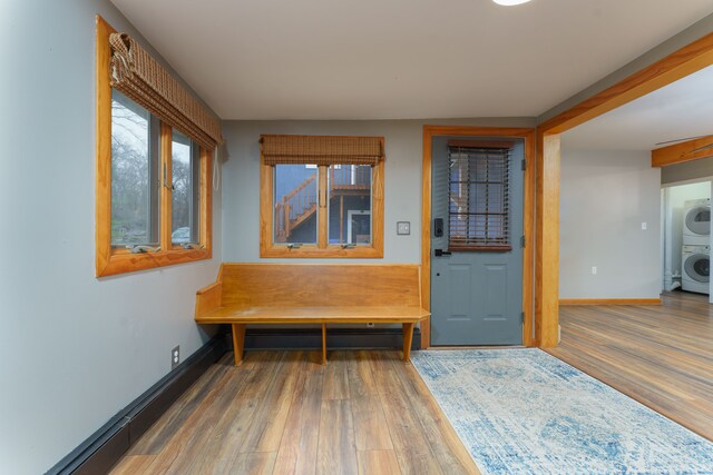 interior space with stacked washer and clothes dryer and hardwood / wood-style flooring