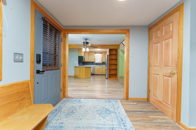 entryway with ceiling fan, sink, and light hardwood / wood-style floors