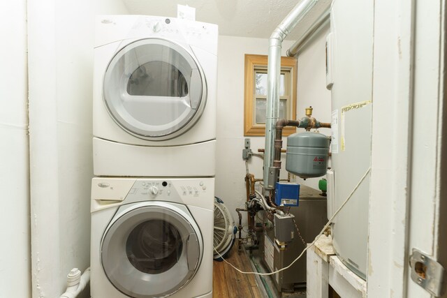 laundry area with dark hardwood / wood-style floors and stacked washer / drying machine