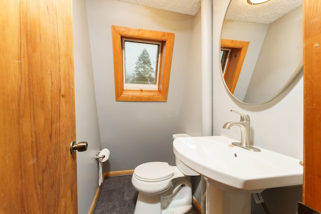 771 Hurley Dr, Howell, MI 48843 - bathroom with toilet, a textured ceiling, baseboards, tile patterned floors, and a skylight