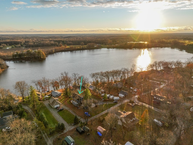 aerial view at dusk featuring a water view