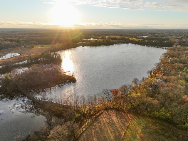 aerial view at dusk featuring a water view