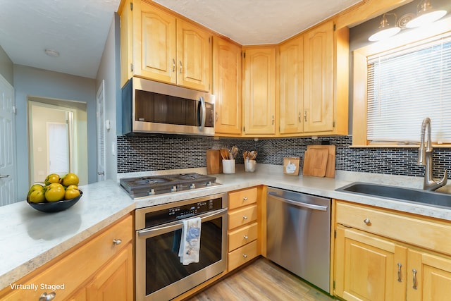 771 Hurley Dr, Howell, MI 48843 - kitchen with stainless steel appliances, a sink, light countertops, and decorative backsplash