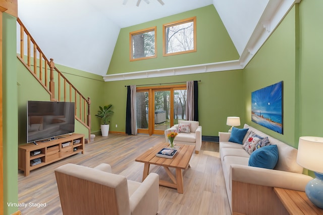 771 Hurley Dr, Howell, MI 48843 - living room with high vaulted ceiling, stairs, wood finished floors, and baseboards