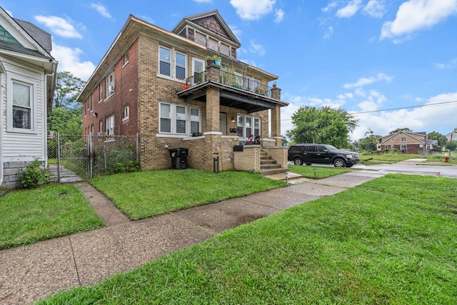 view of front facade featuring a front yard and a balcony