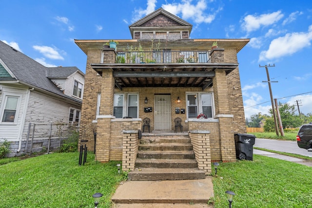 view of front of house with a balcony and a front lawn