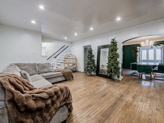 living room with light hardwood / wood-style flooring, a wealth of natural light, and an inviting chandelier