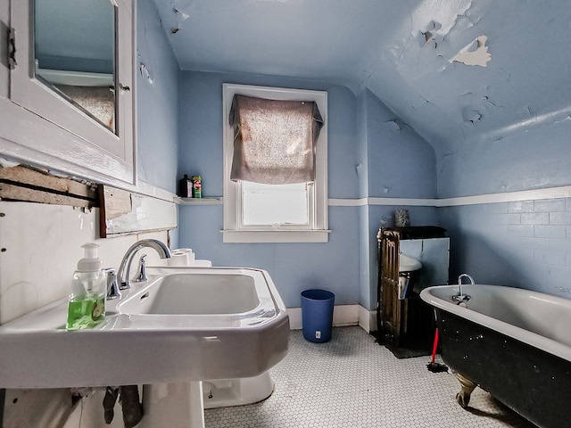 bathroom with a bath and lofted ceiling