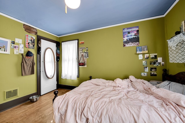 bedroom with light hardwood / wood-style floors and ornamental molding