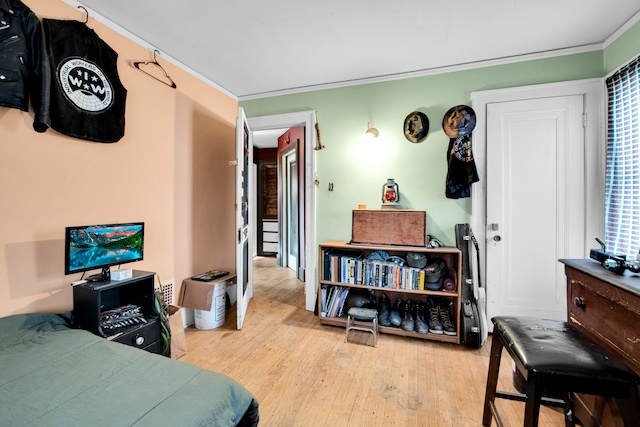 bedroom featuring light hardwood / wood-style flooring and crown molding