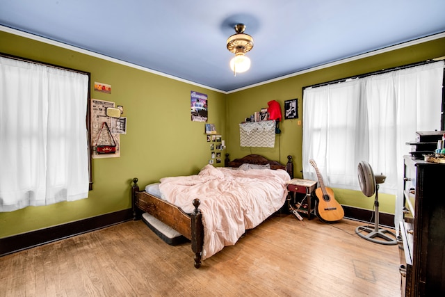 bedroom featuring hardwood / wood-style flooring and crown molding