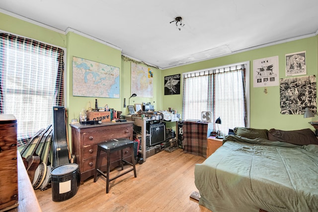 bedroom featuring ornamental molding and light hardwood / wood-style flooring