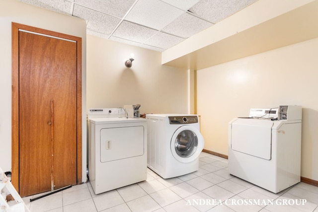 clothes washing area featuring washing machine and clothes dryer and light tile patterned flooring