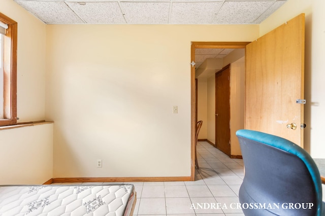 interior space with a drop ceiling and light tile patterned floors