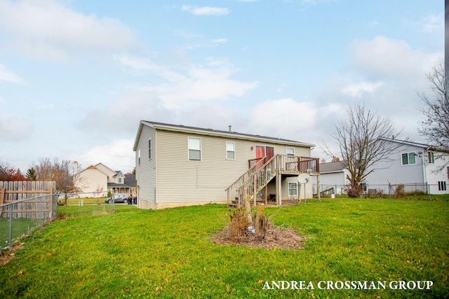 rear view of house with a wooden deck and a lawn