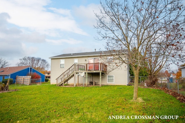 rear view of house featuring a deck and a yard