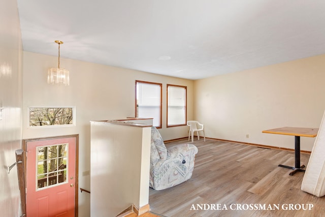 living area with a notable chandelier and light hardwood / wood-style flooring