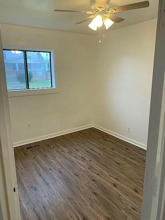 empty room featuring dark hardwood / wood-style floors and ceiling fan