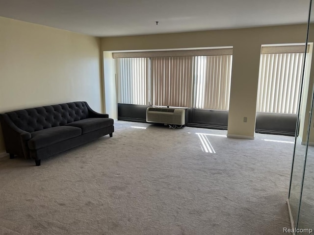 carpeted living area with plenty of natural light and a wall mounted AC