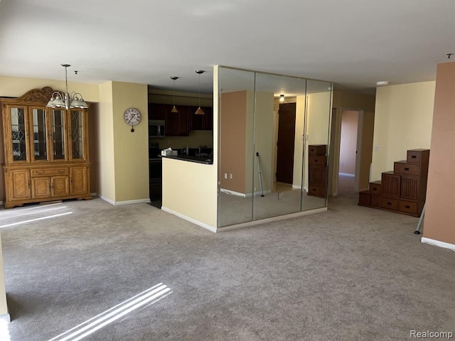 interior space with light carpet, a chandelier, and baseboards