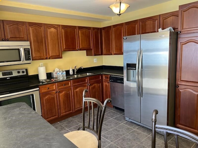 1001 W Jefferson Ave Unit 300/12A, Detroit, MI 48226 - kitchen featuring a sink, dark countertops, dark tile patterned floors, and appliances with stainless steel finishes