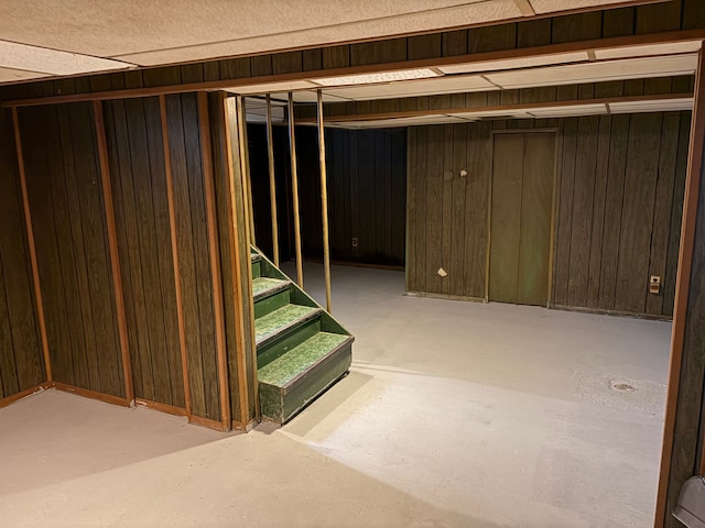 basement featuring wood walls