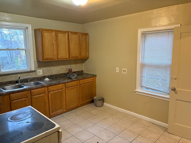 kitchen featuring stove, light tile patterned floors, and sink