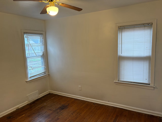 empty room with dark hardwood / wood-style flooring and ceiling fan