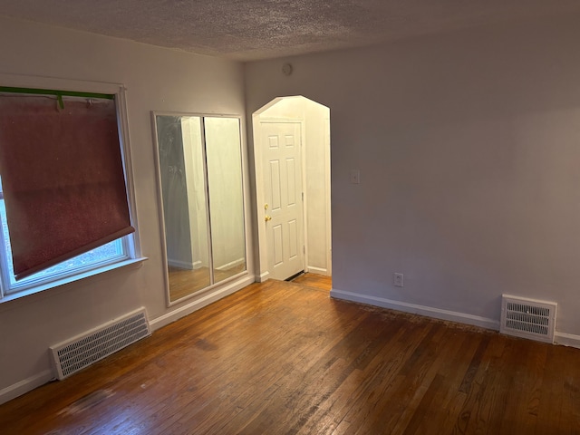 empty room featuring a textured ceiling and hardwood / wood-style flooring