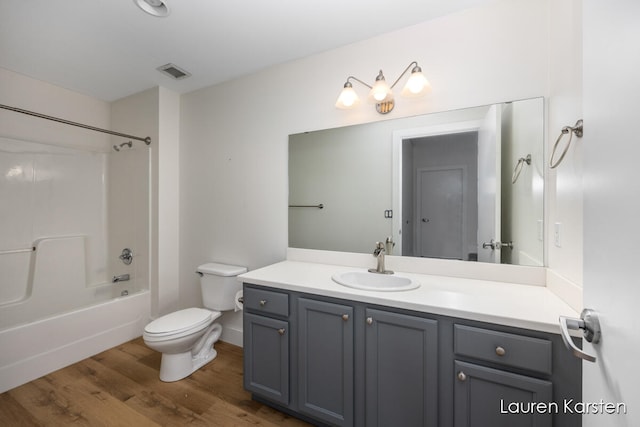 full bathroom featuring shower / bathing tub combination, wood-type flooring, vanity, and toilet