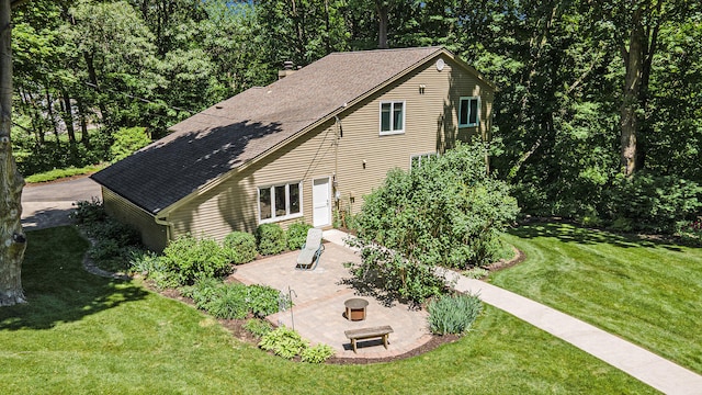 back of house with a yard and a patio