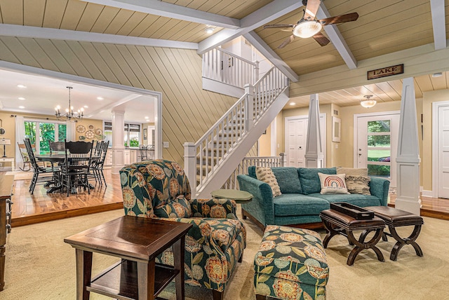 living room featuring ceiling fan with notable chandelier, vaulted ceiling with beams, hardwood / wood-style flooring, and wooden walls