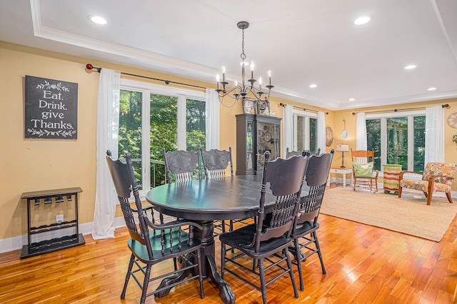 dining area featuring light hardwood / wood-style floors, crown molding, and a notable chandelier